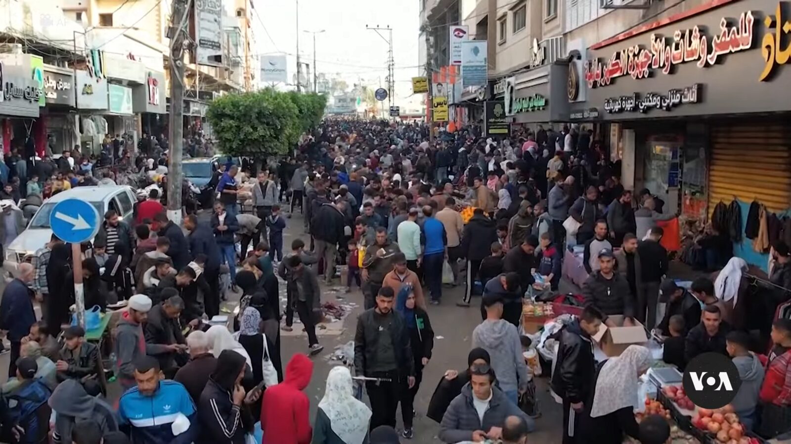 Drone footage still showing aftermath of an airstrike in Deir al-Balah — a cloud of dust rising from a freshly destroyed building surrounded by already-damaged structures.