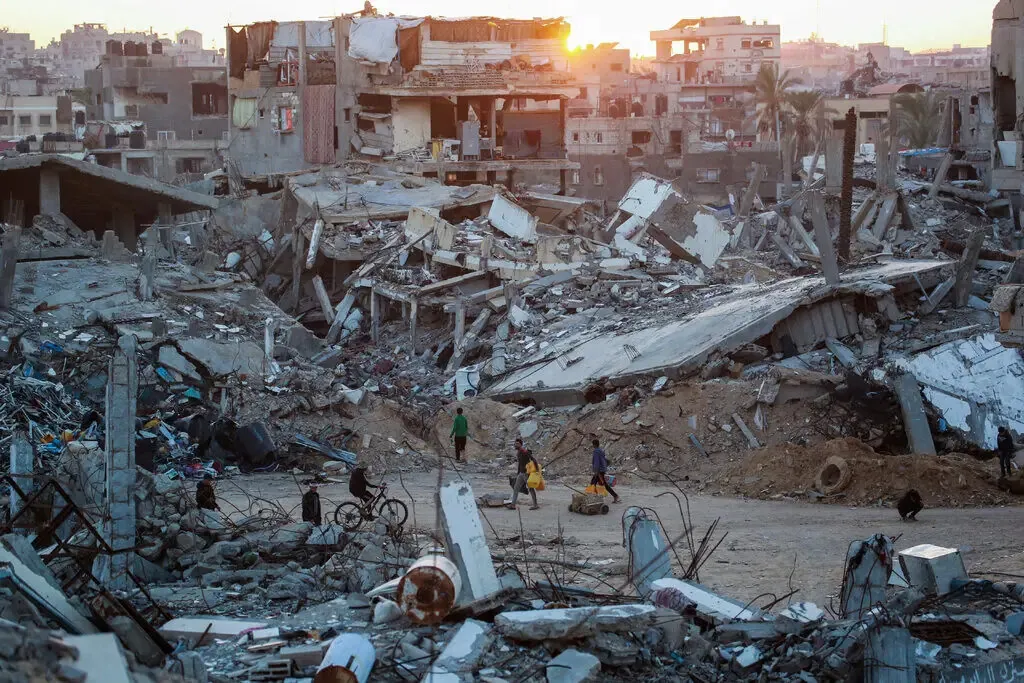 A panoramic street view in Khan Younis showing block after block of structurally compromised multi-story buildings.