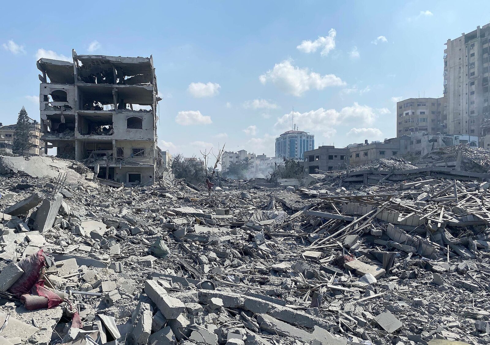 Wide view of rubble-strewn streets and collapsed buildings in the Al-Rimal neighborhood of Gaza City following an Israeli airstrike, October 2023.