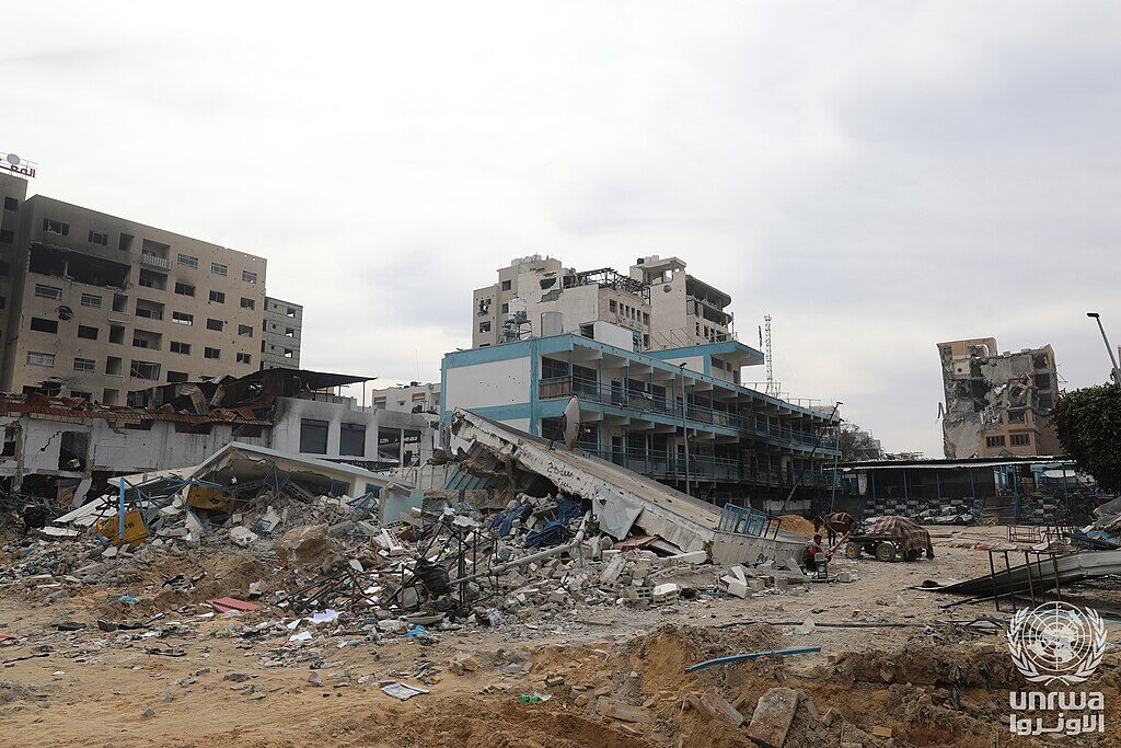 The destroyed UNRWA Zaitoun Boys School — classroom blocks collapsed, schoolyard filled with debris.